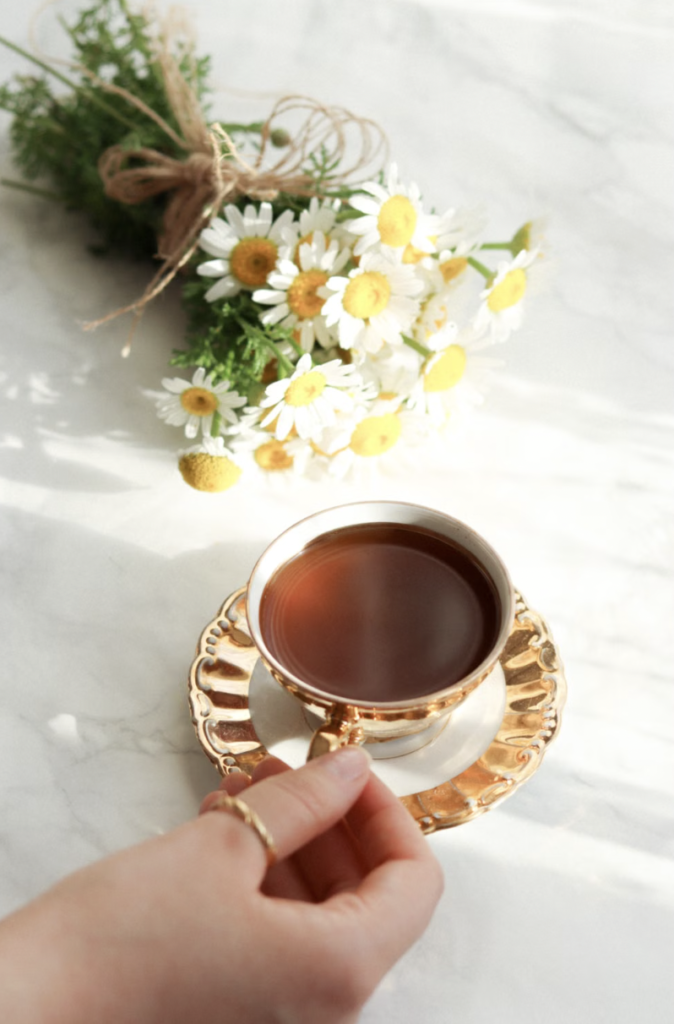 A delicate setting with chamomile flowers and a cup of tea, perfect for a serene morning ritual.